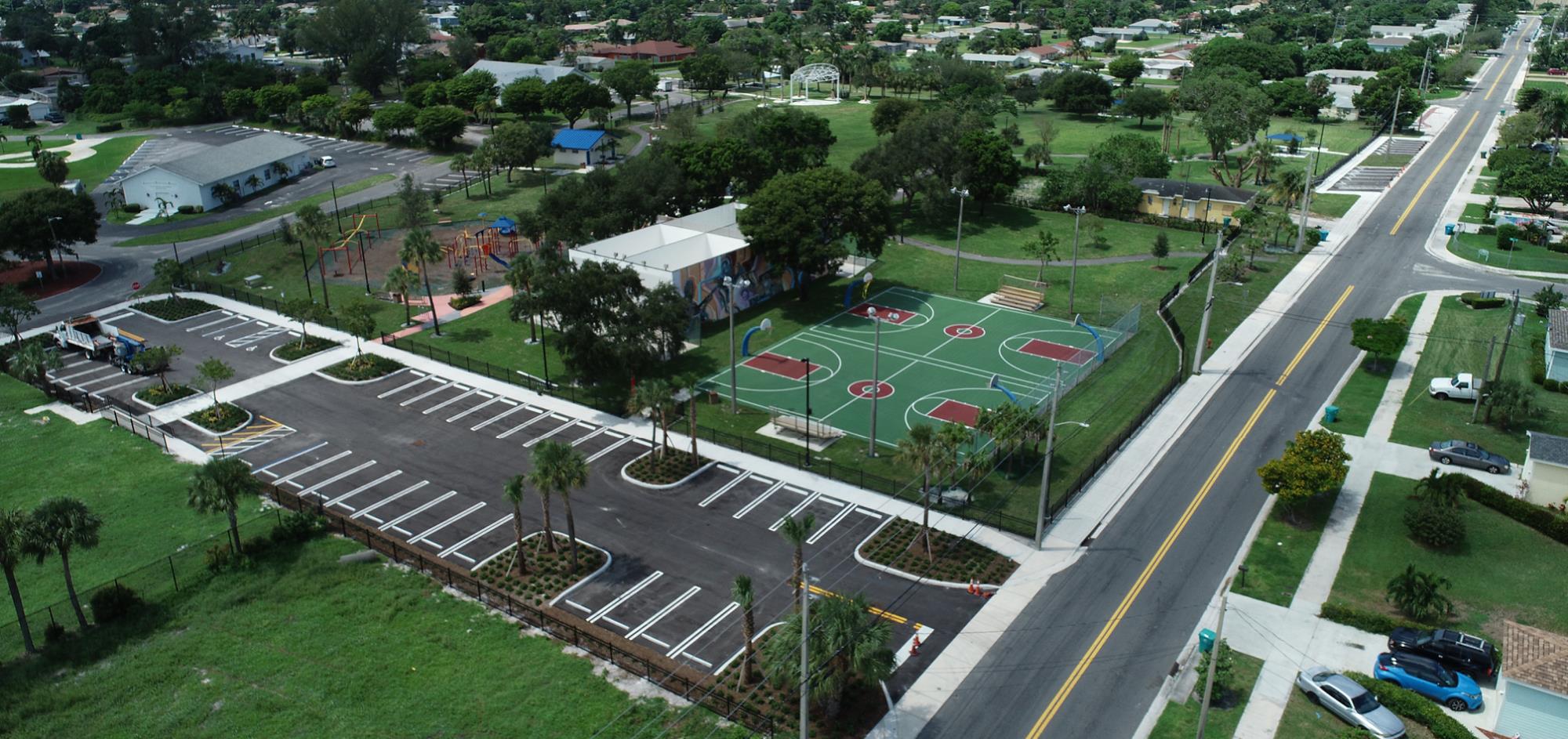 Aerial view from East with parking lot and basketball courts with fresh landscaping surrounding